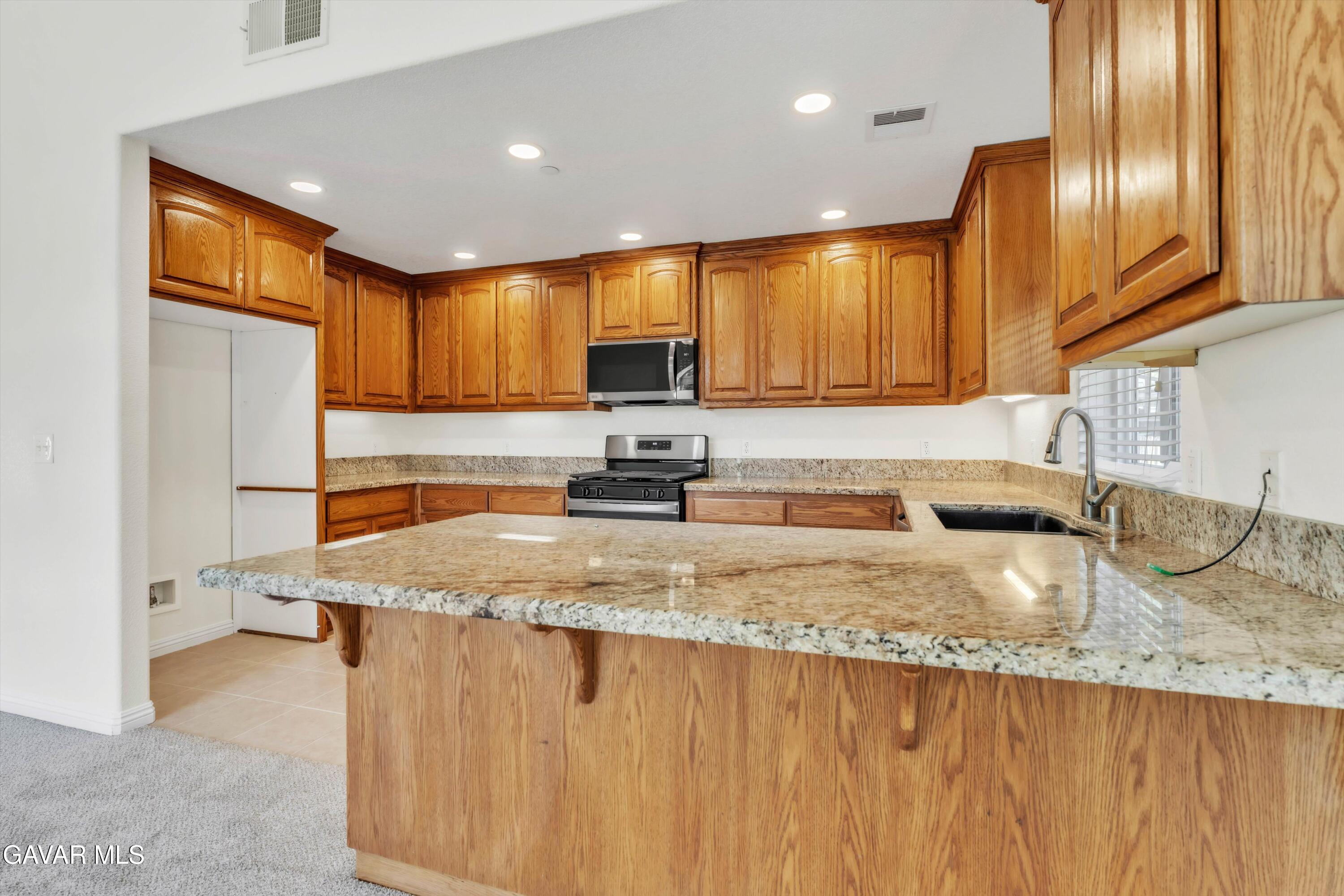 17819 Elizabeth Lake Road Lake Hughes, CA 93532 - Photo 5 of 28 a kitchen with stainless steel appliances granite countertop a sink a stove and a refrigerator