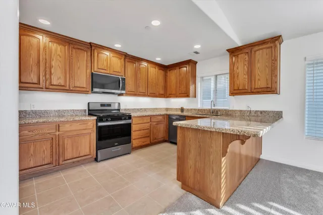 a spacious bathroom with a granite countertop double vanity sink a window and a mirror