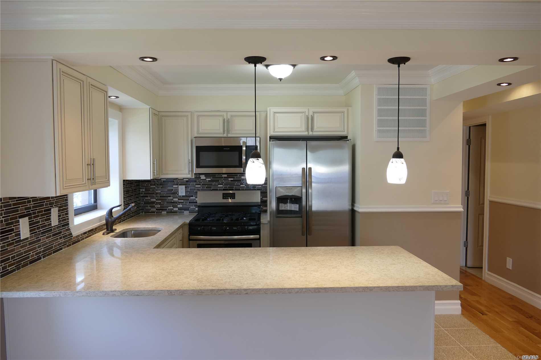 75-32 Parsons Boulevard Queens, NY 11367 - Photo 1 of 1 a kitchen with granite countertop a refrigerator a sink a stove and cabinets