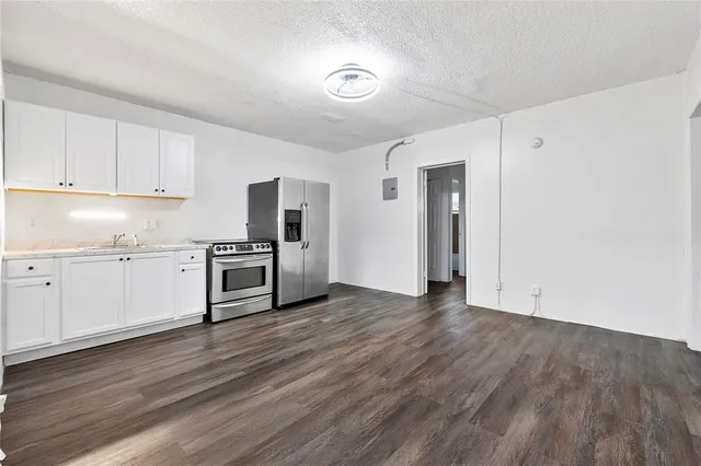 a view of a kitchen with a sink and a refrigerator