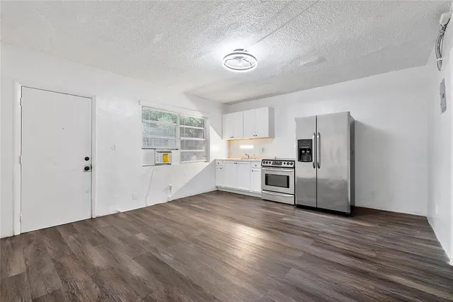 a view of a kitchen with wooden floor and electronic appliances