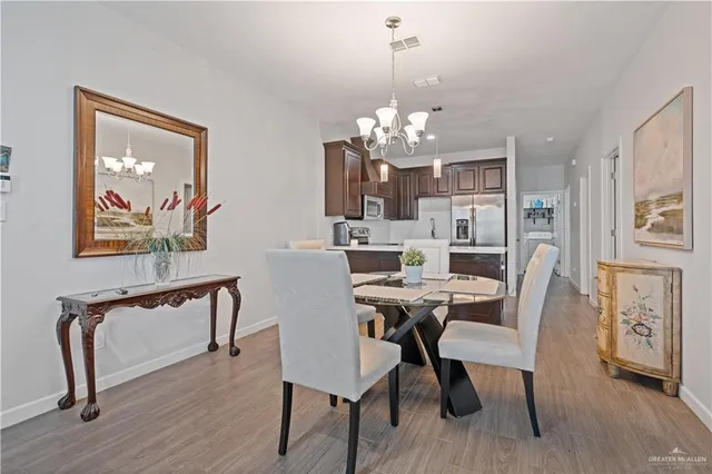 a view of a dining room with furniture a chandelier and wooden floor