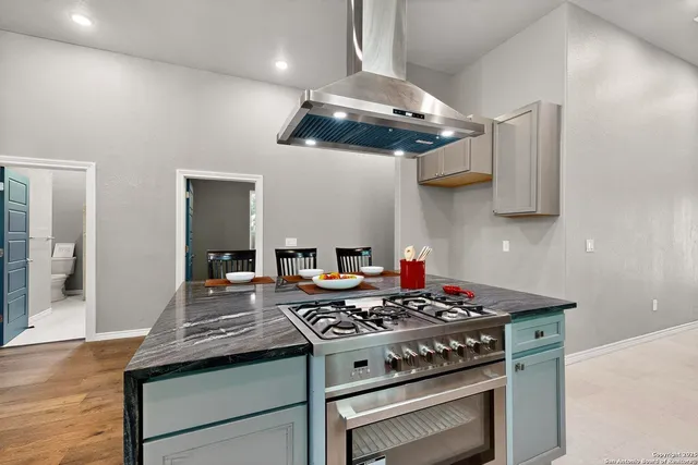 a kitchen with a stove and a wooden floor