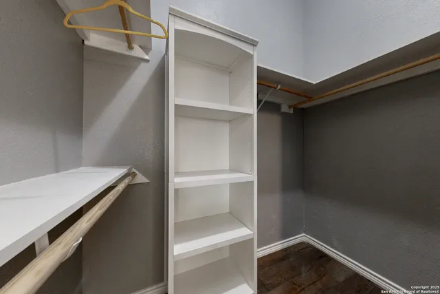 a view of walk in closet with empty racks