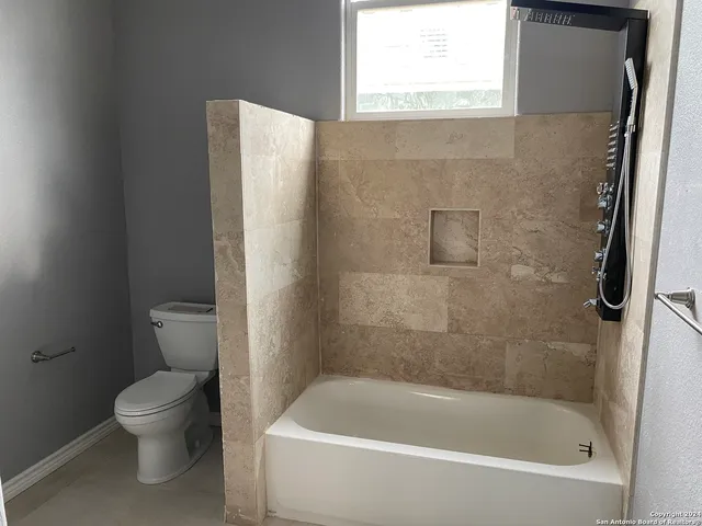 a spacious bathroom with a granite countertop sink a mirror and shower