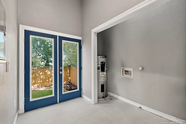 a view of a backyard with a large tree and wooden fence