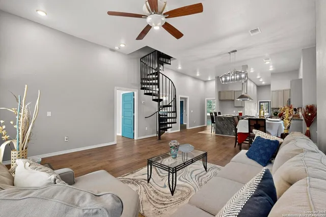 a living room with furniture kitchen view and a chandelier