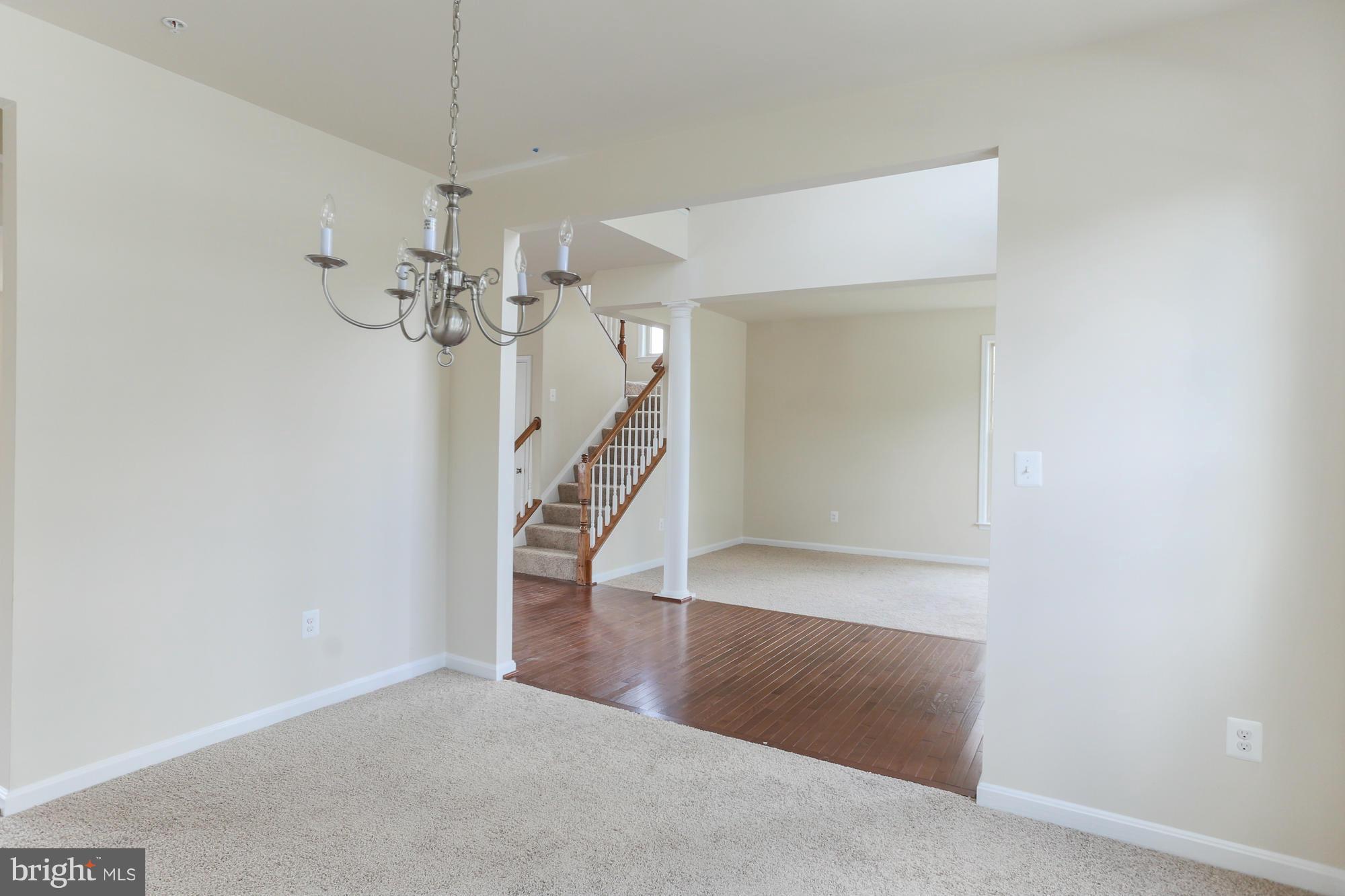 9404 Cross Road Perry Hall, MD 21128 - Photo 7 of 30 an empty room with wooden floor staircase and a chandelier