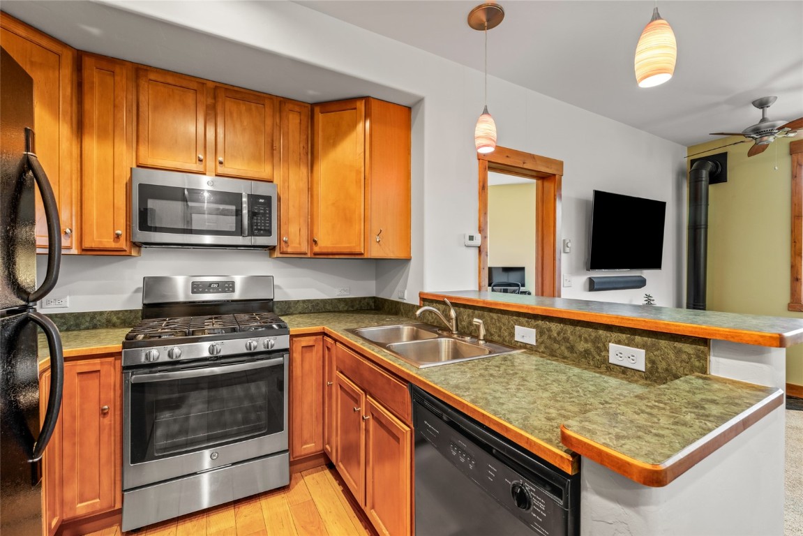 35 11th Street, Unit B Steamboat Springs, CO 80487 - Photo 7 of 18 a kitchen with granite countertop wooden cabinets stainless steel appliances and a window