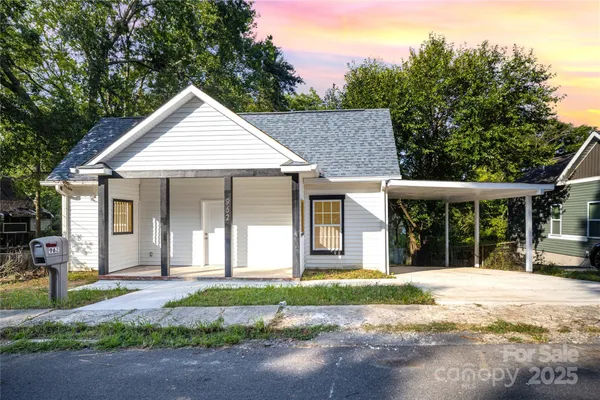 a front view of a house with a yard and potted plants
