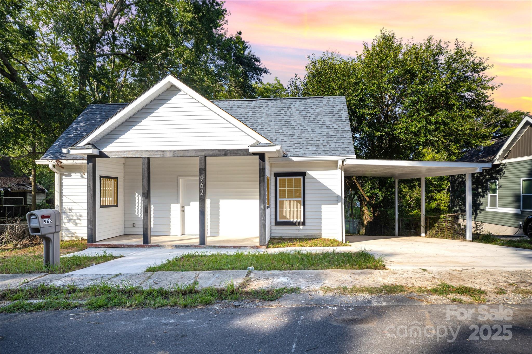 a front view of a house with a yard and potted plants