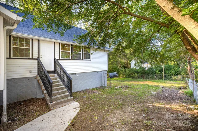 a view of a house with backyard and trees