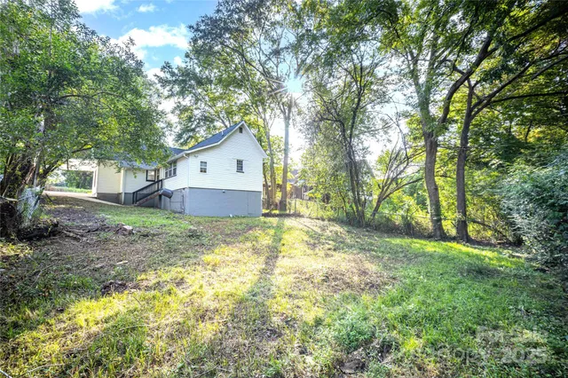 a view of a house with a yard and large tree