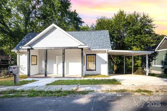 a front view of a house with a yard and potted plants