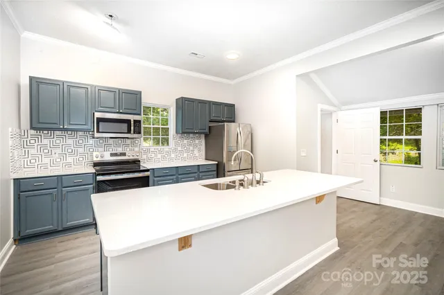 a kitchen with a sink a stove a refrigerator a kitchen island and chairs