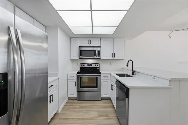 a kitchen with stainless steel appliances granite countertop a stove a sink and a refrigerator