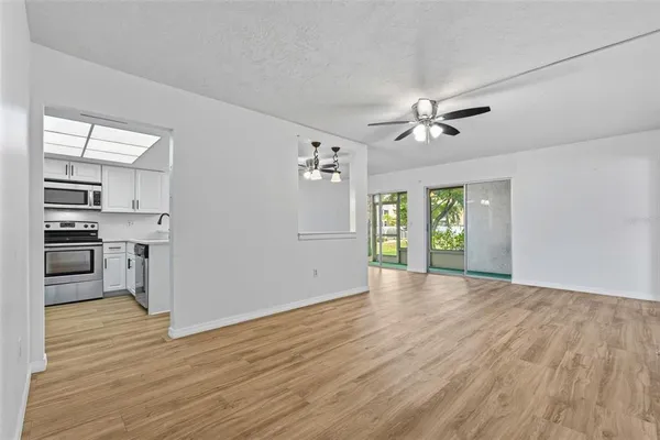 a view of an empty room with window and wooden floor