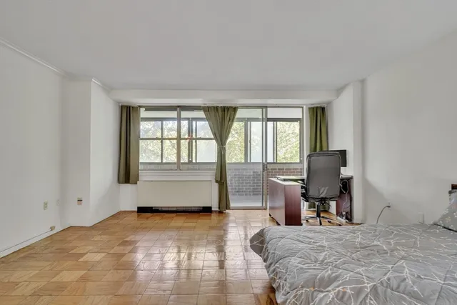 a bedroom with a bed and wooden floor
