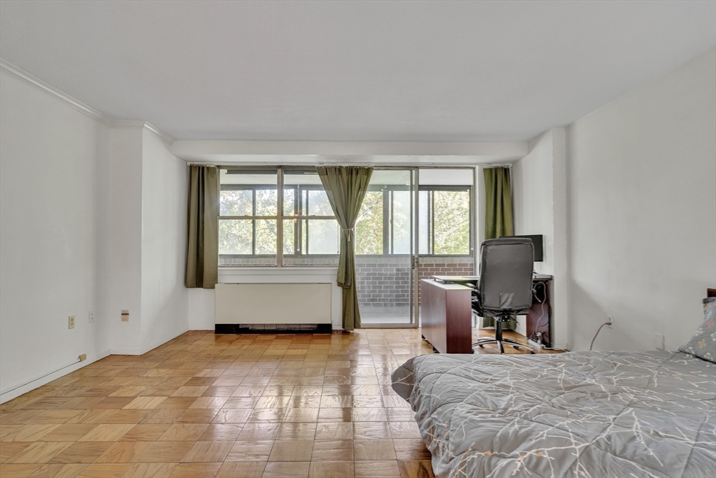 9 Hawthorne Place, Unit 5K Boston, MA 02114 - Photo 17 of 37 a bedroom with a bed and wooden floor
