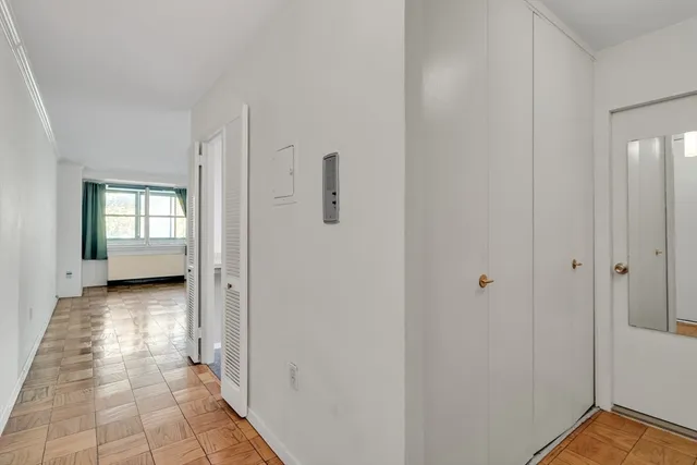 a view of a hallway with bathroom and wooden floor
