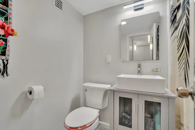 a bathroom with a sink a toilet and mirror