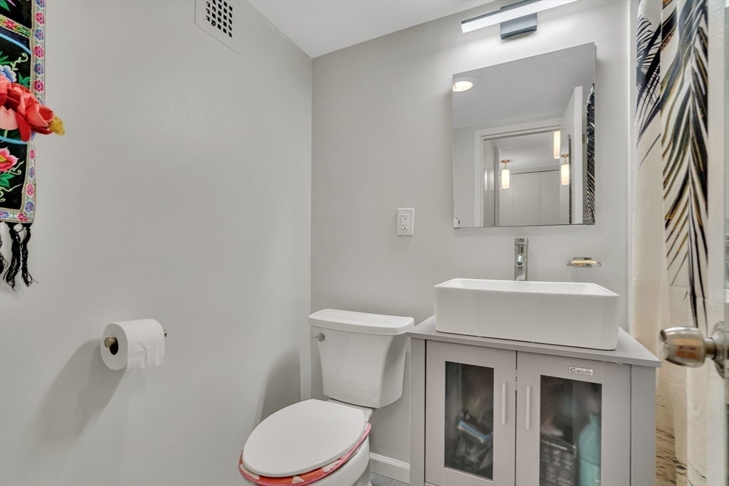 9 Hawthorne Place, Unit 5K Boston, MA 02114 - Photo 21 of 37 a bathroom with a sink a toilet and mirror