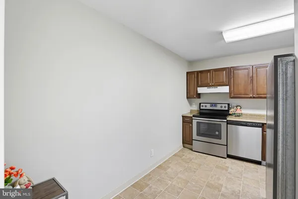 a kitchen with granite countertop white cabinets and stainless steel appliances