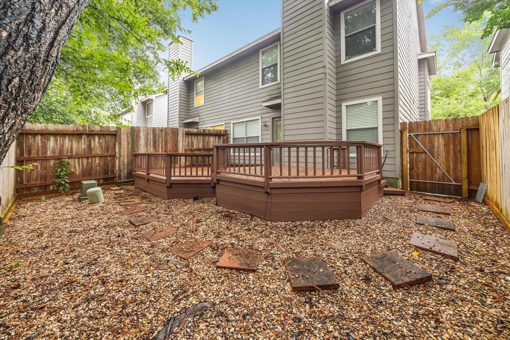 227 Blushwood Place Spring, TX 77382 - Photo 30 of 30 Low-maintenance backyard with private fencing, mature trees, and a raised deck—ideal for outdoor dining, entertaining, or relaxing in the shade.