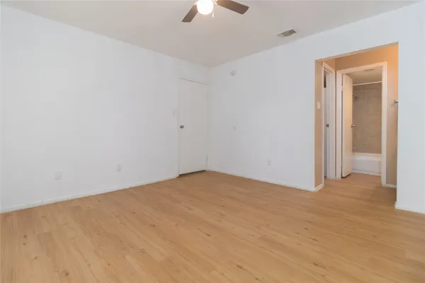 a view of an empty room and chandelier fan