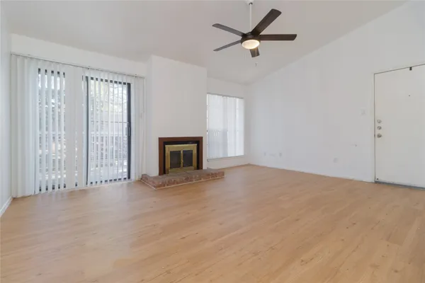 a view of an empty room with a fireplace and a window