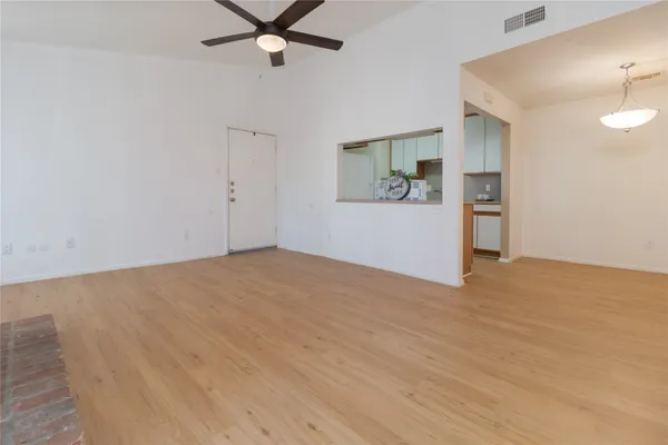 a view of a livingroom with wooden floor and a ceiling fan