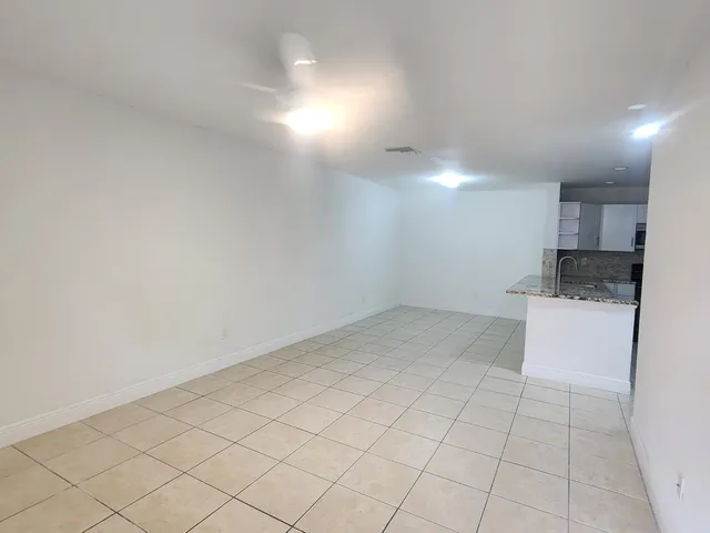 a view of kitchen with white cabinets and sink
