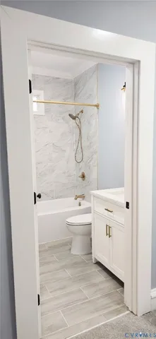 a bathroom with a granite countertop sink a toilet a mirror a bathtub and shower