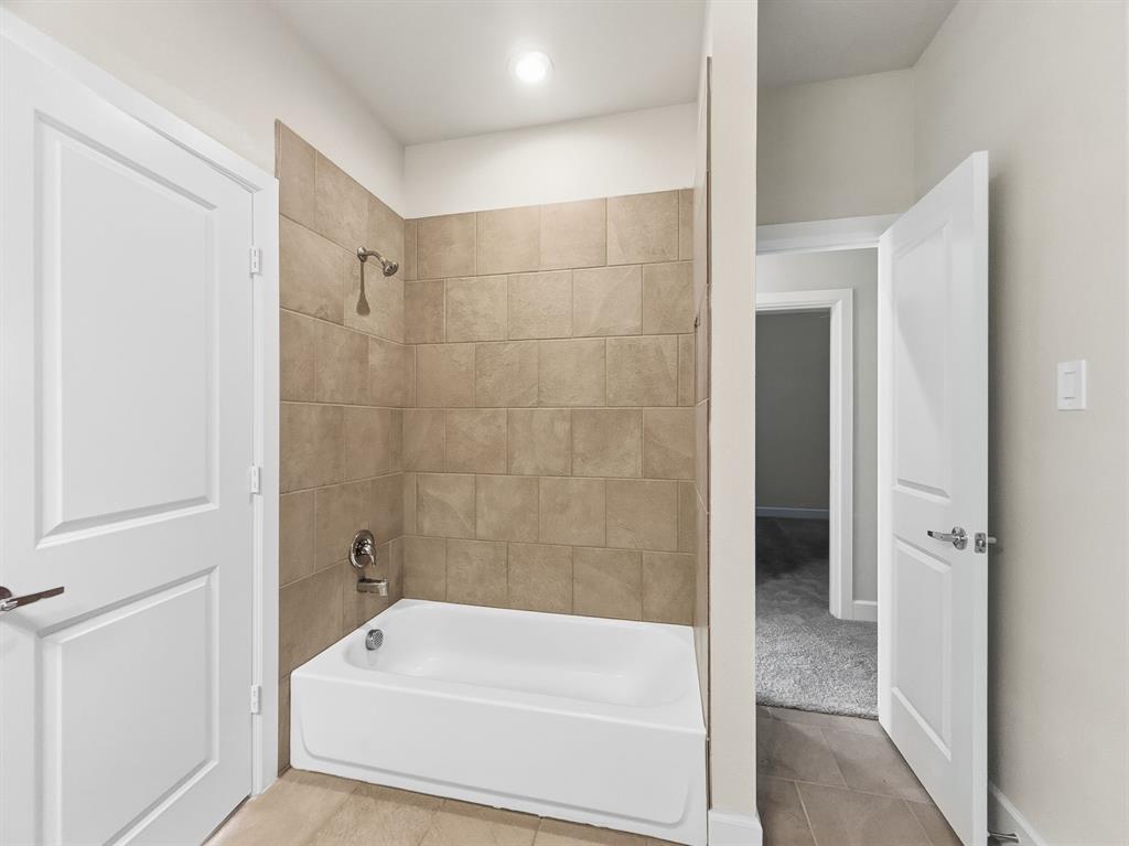 5704 Woodlands Drive The Colony, TX 75056 - Photo 15 of 23 a bathroom with a bathtub and a shower