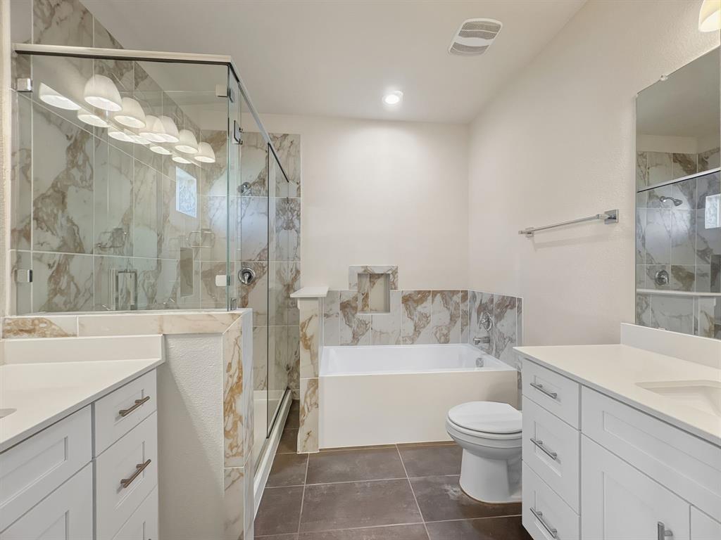 5704 Woodlands Drive The Colony, TX 75056 - Photo 19 of 23 a bathroom with a bathtub shower sink vanity and toilet