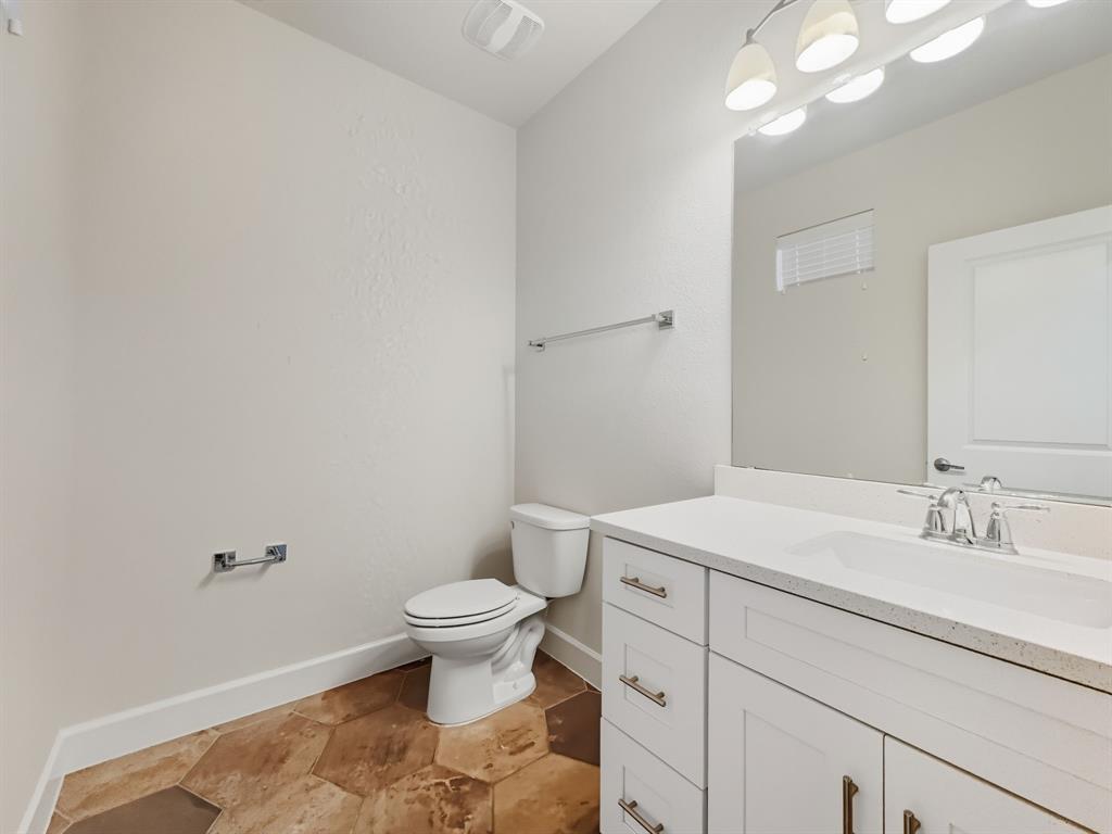 5704 Woodlands Drive The Colony, TX 75056 - Photo 7 of 23 a bathroom with a sink toilet vanity and a mirror