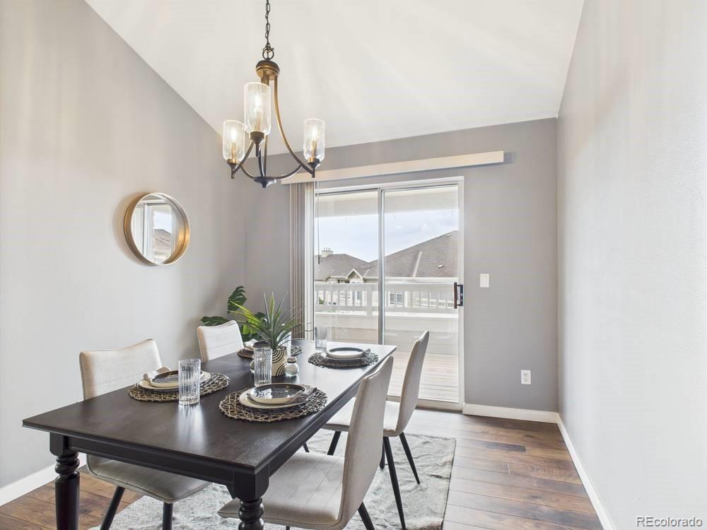 a view of a dining room with furniture a chandelier and wooden floor