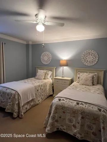 a bedroom with two bed and a chandelier