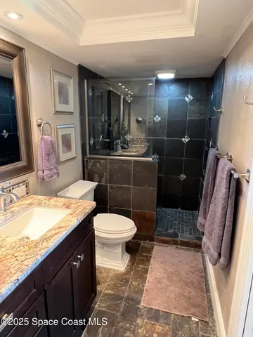a bathroom with a granite countertop sink toilet and shower