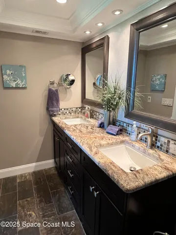 a bathroom with a granite countertop sink a mirror and a shower