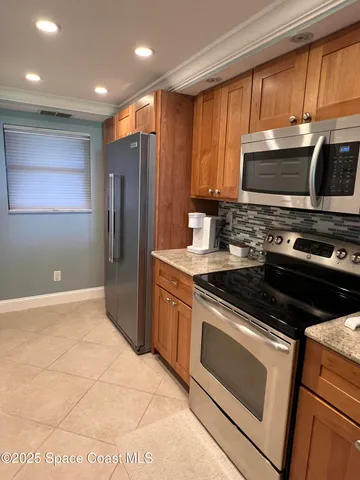 a kitchen with stainless steel appliances granite countertop a stove a refrigerator and a microwave