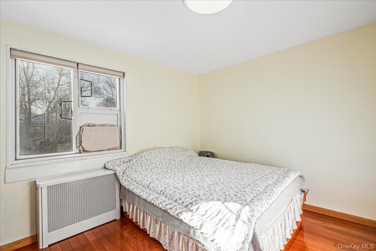 218-07 73rd Avenue, Unit UPPR Queens, NY 11364 - Photo 13 of 23 a bedroom with a bed and wooden floor