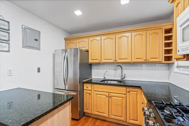 a kitchen with stainless steel appliances granite countertop a sink stove and refrigerator