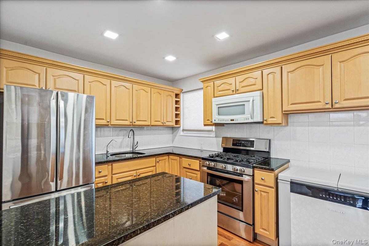 218-07 73rd Avenue, Unit UPPR Queens, NY 11364 - Photo 5 of 23 a kitchen with stainless steel appliances granite countertop a refrigerator a sink and white cabinets