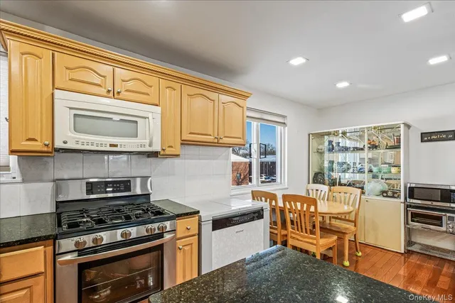 a kitchen with stainless steel appliances granite countertop a stove a sink and a microwave