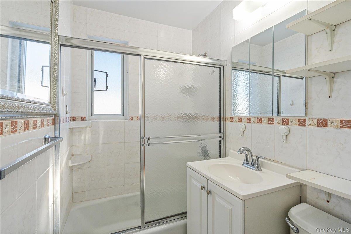 218-07 73rd Avenue, Unit UPPR Queens, NY 11364 - Photo 10 of 23 a bathroom with a sink toilet and shower