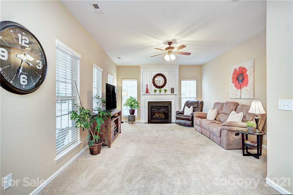 7025 Meyer Road Fort Mill, SC 29715 - Photo 15 of 41 a living room with furniture a fireplace and a flat screen tv