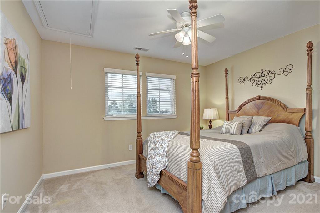 7025 Meyer Road Fort Mill, SC 29715 - Photo 23 of 41 a bedroom with a bed and a chandelier