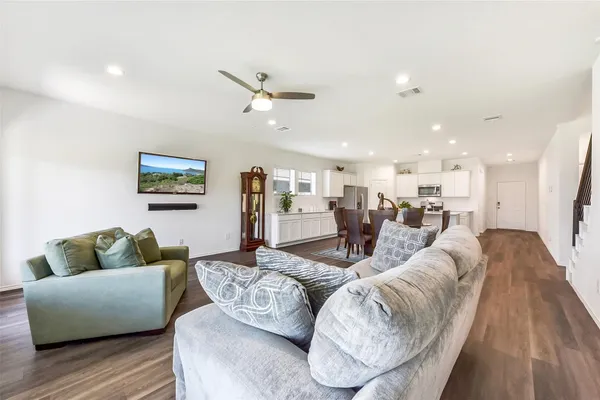 a living room with furniture and a wooden floor