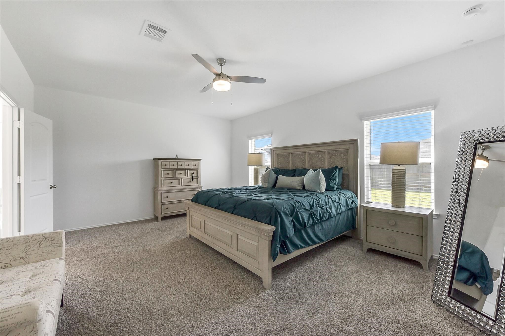 4985 Blue Beetle Rdg Drive Katy, TX 77493 - Photo 16 of 40 a bedroom with a large bed and a chandelier